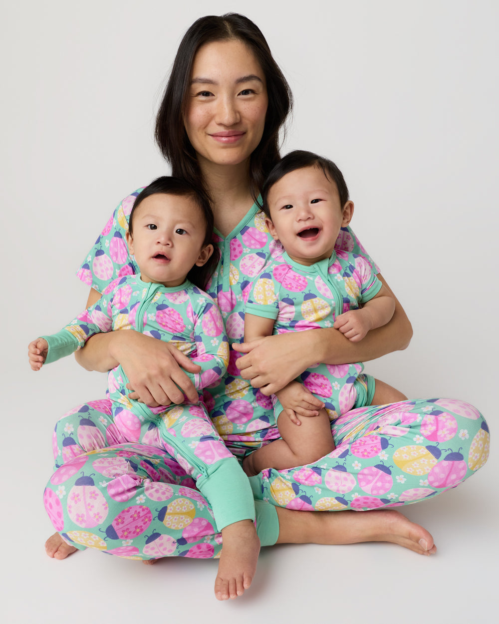Mother and two children wearing matching ladybug print pajamas