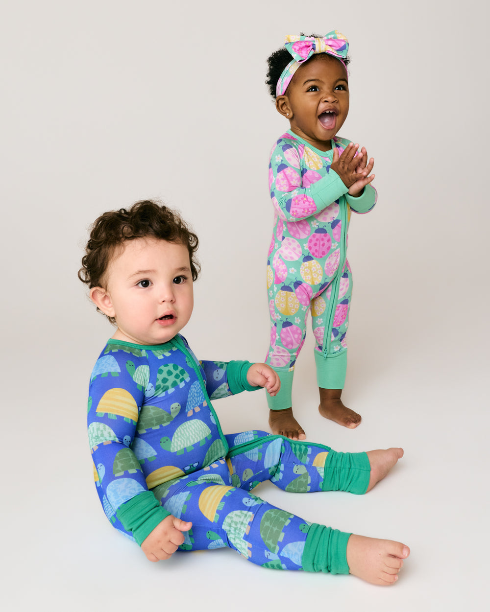 Two children wearing turtle and ladybug printed bamboo pajamas 