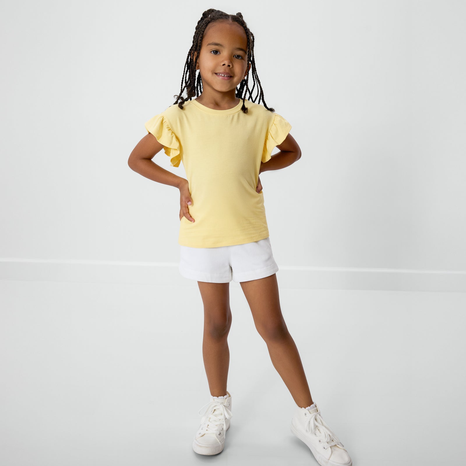 Standing child wearing the Lemon Twist Ruffle Tee with bamboo shorts