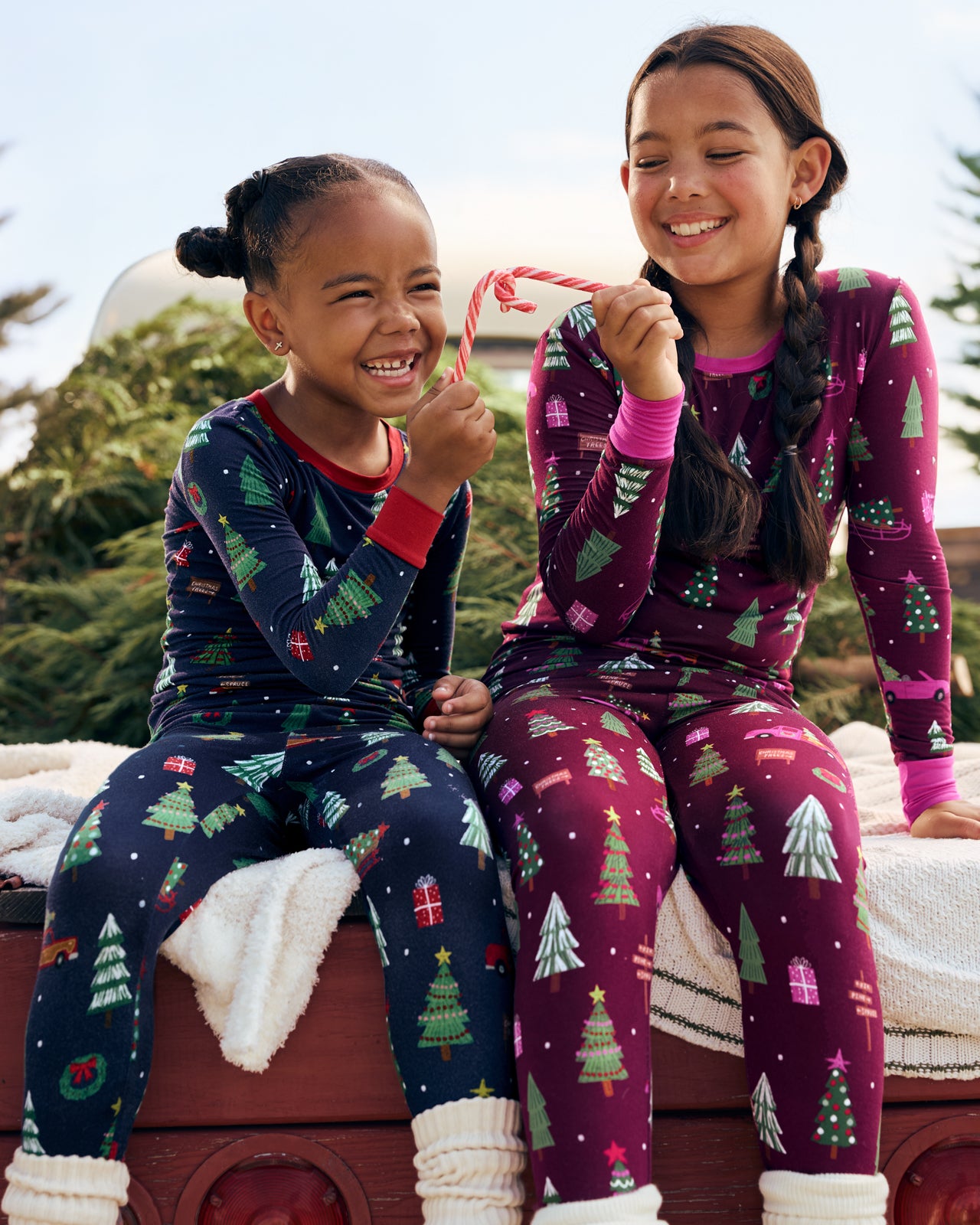 Two girls wearing matching Navy and Cranberry Tree Traffic Two-Piece Pajama Sets