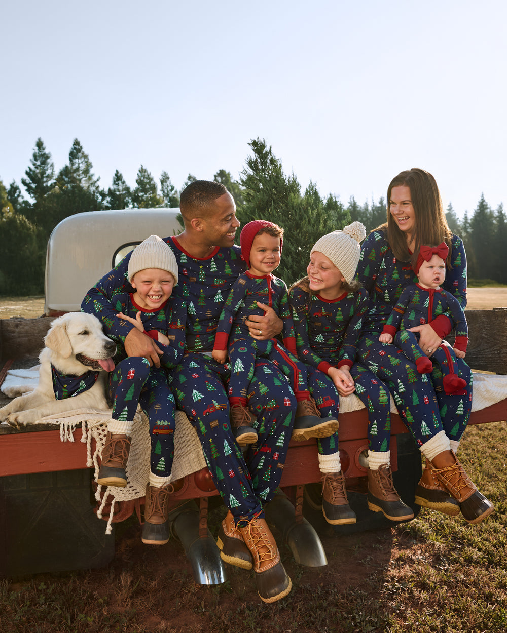 Family of six and their dog wearing coordinating Christmas pajamas