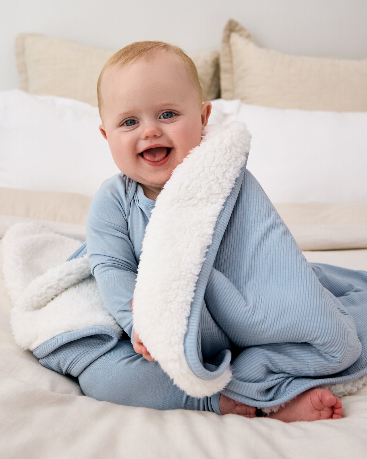 Baby wrapped in the Light Fog Layette Ribbed Cloud Blanket