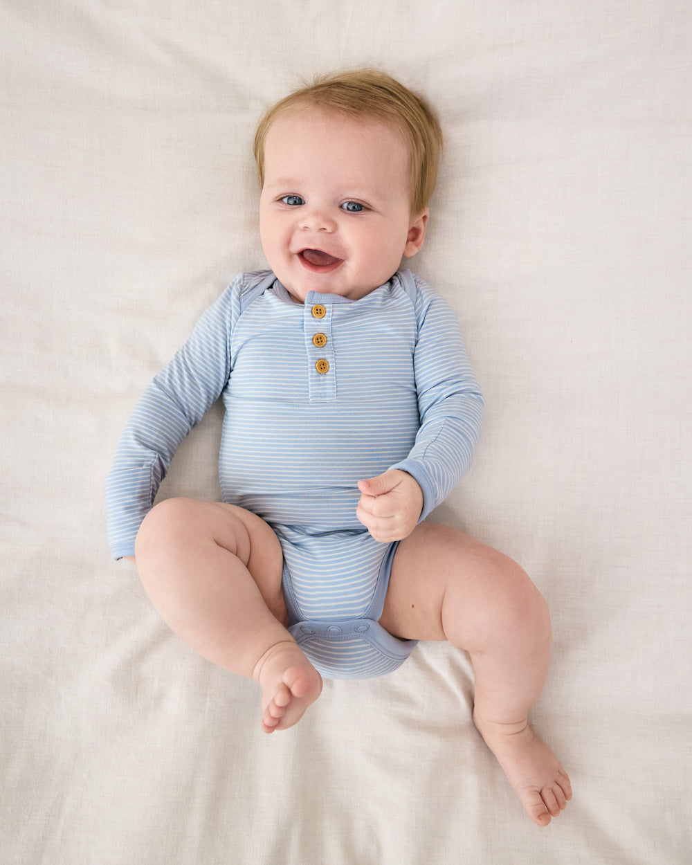 Aerial view of baby wearing the Light Fog Stripe Henley Bodysuit