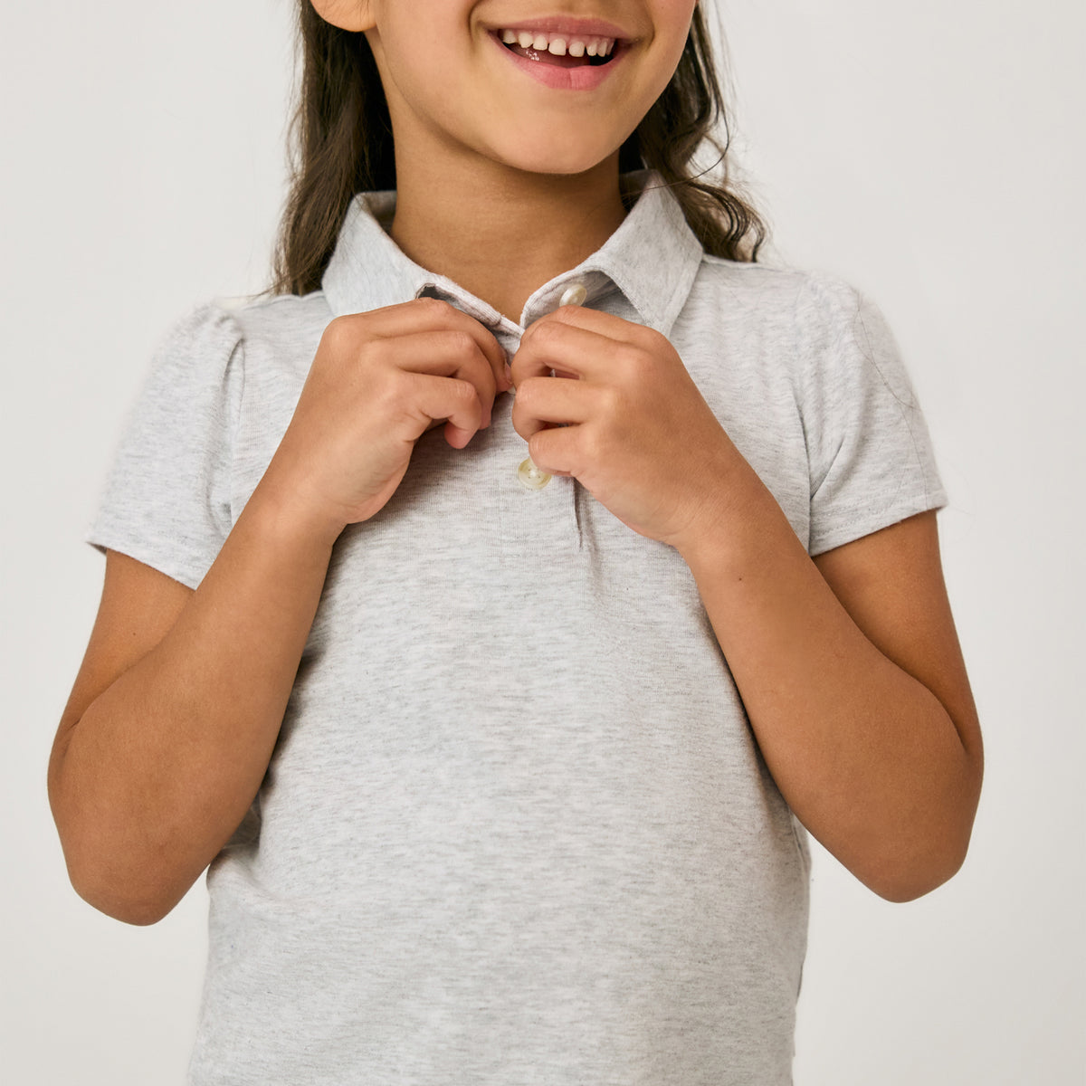 Close up of child doing the buttons on the Light Heather Gray Puff Sleeve Polo