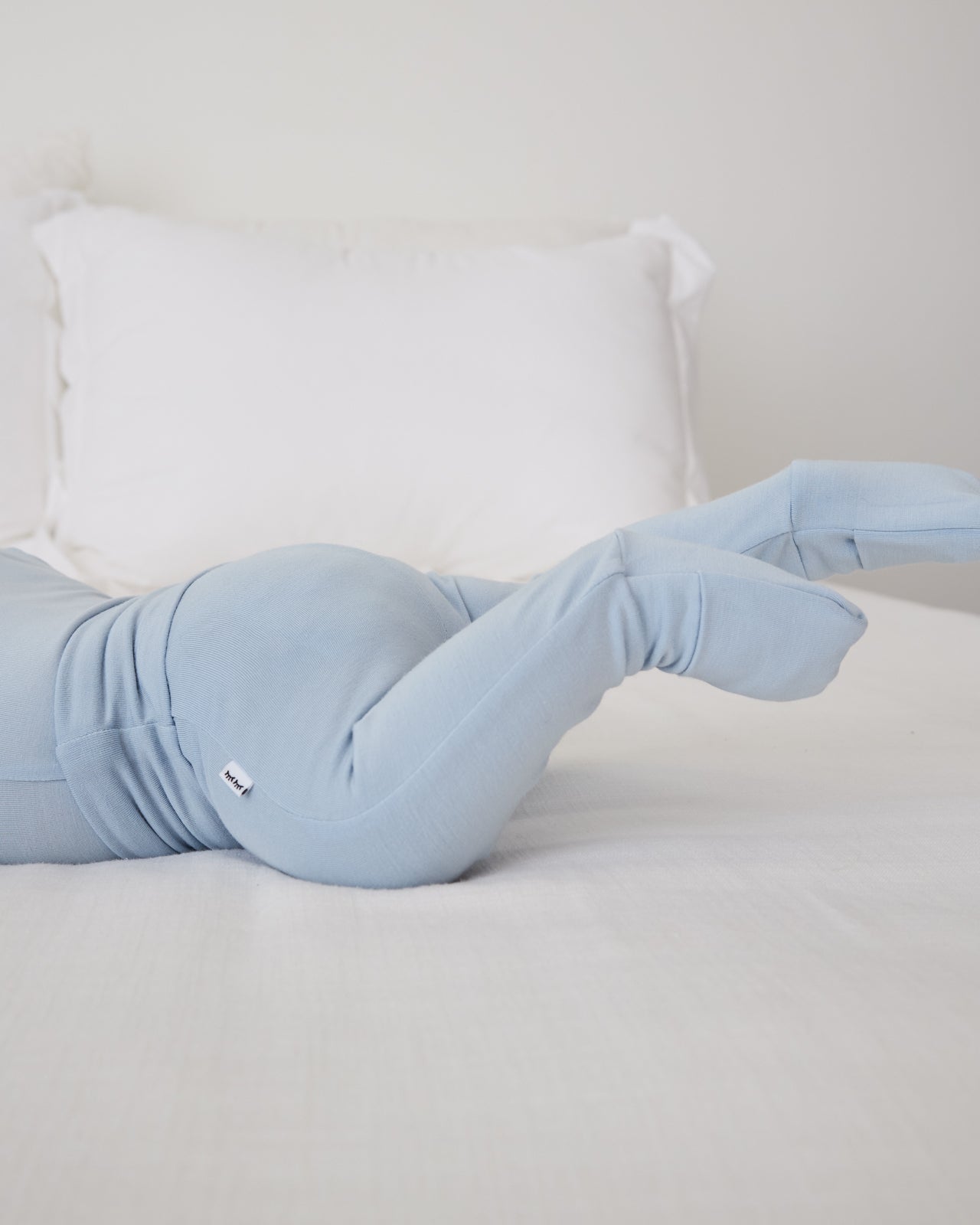 Baby wearing the Light Fog Fold Over Legging on a white bed