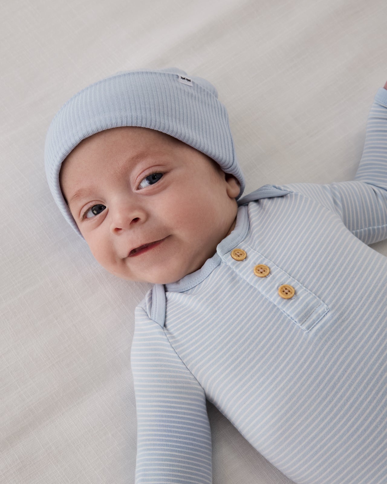 Baby boy wearing the Light Fog Ribbed Infant Beanie