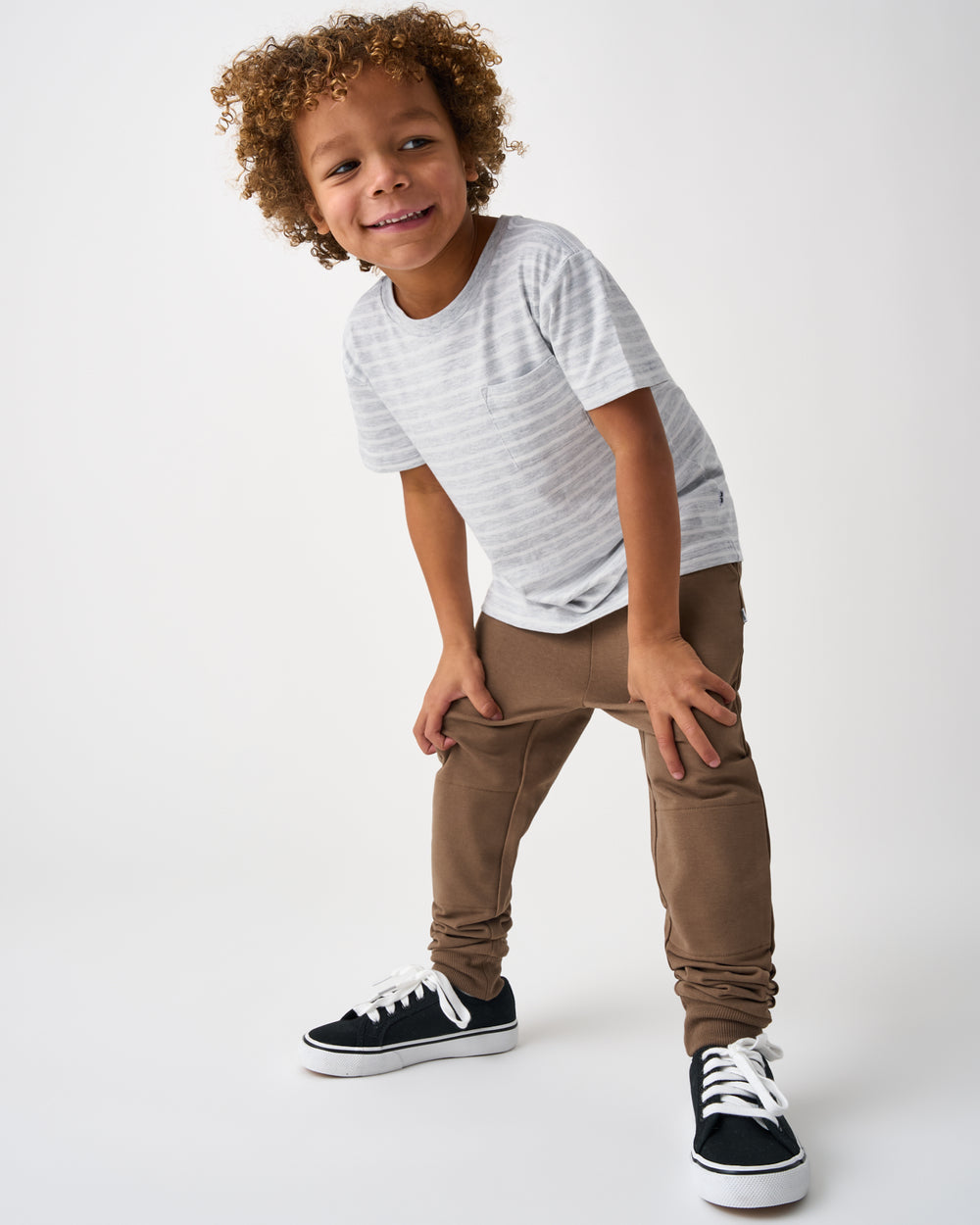 Boy wearing the Light Heather Gray Stripes Relaxed Pocket Tee with brown joggers