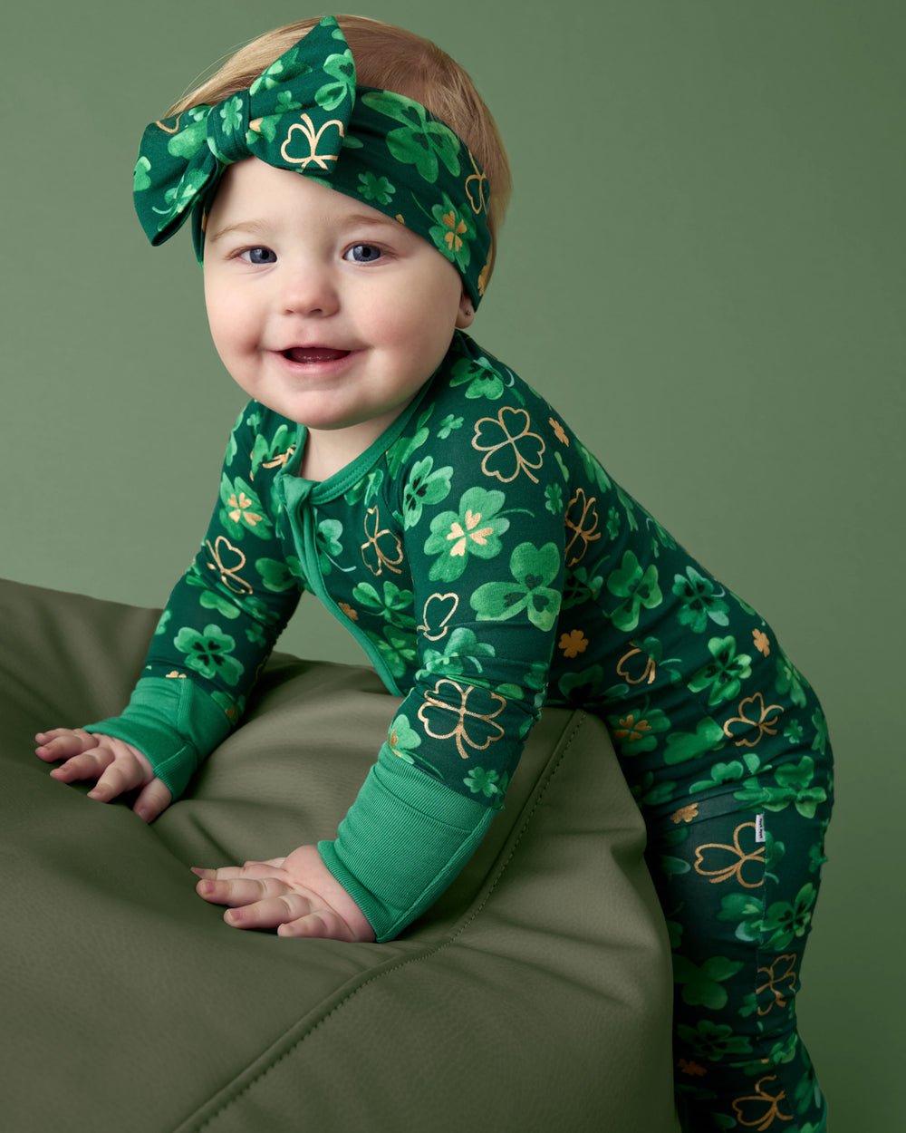 Baby leaning on an ottoman wearing the Clover Cuties Luxe Bow Headband