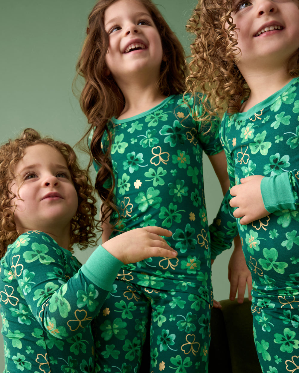 Three children wearing matching Clover Cuties Two-Piece Pajama Sets 