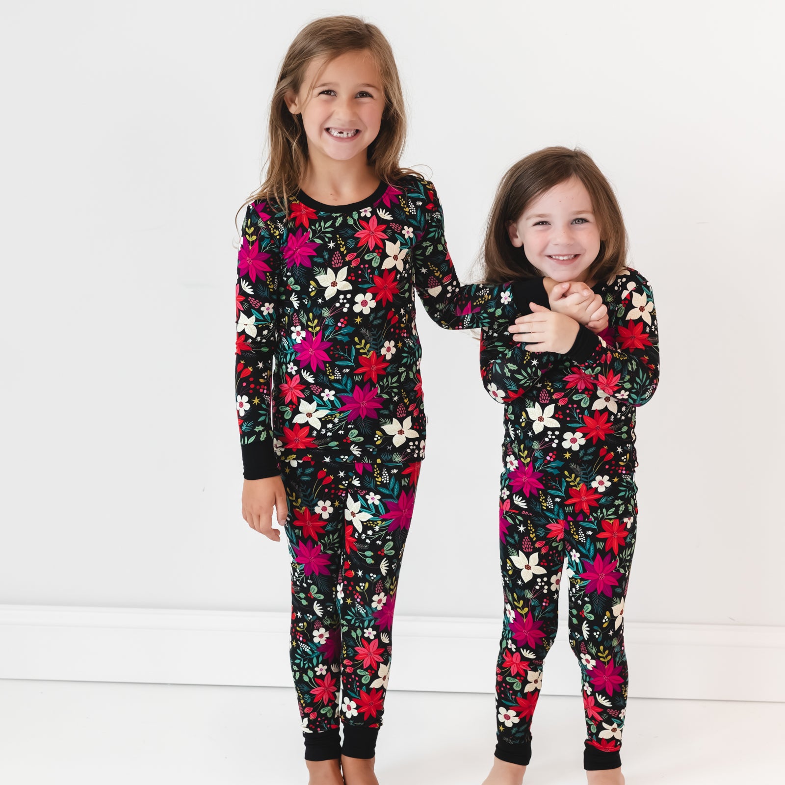 Two girls wearing the Berry Merry Two-Piece Pajama Set