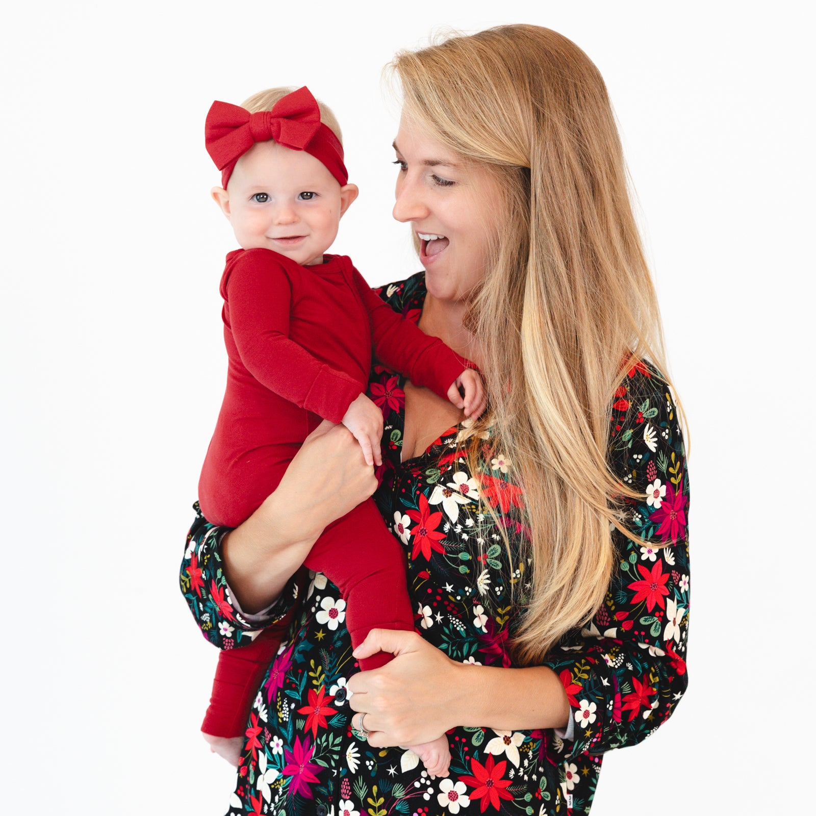 Baby is wearing the Holiday Red Zippy and Holiday Red Luxe Bow Headband and female model is wearing the Berry Merry Women's Long Sleeve Pajama Set