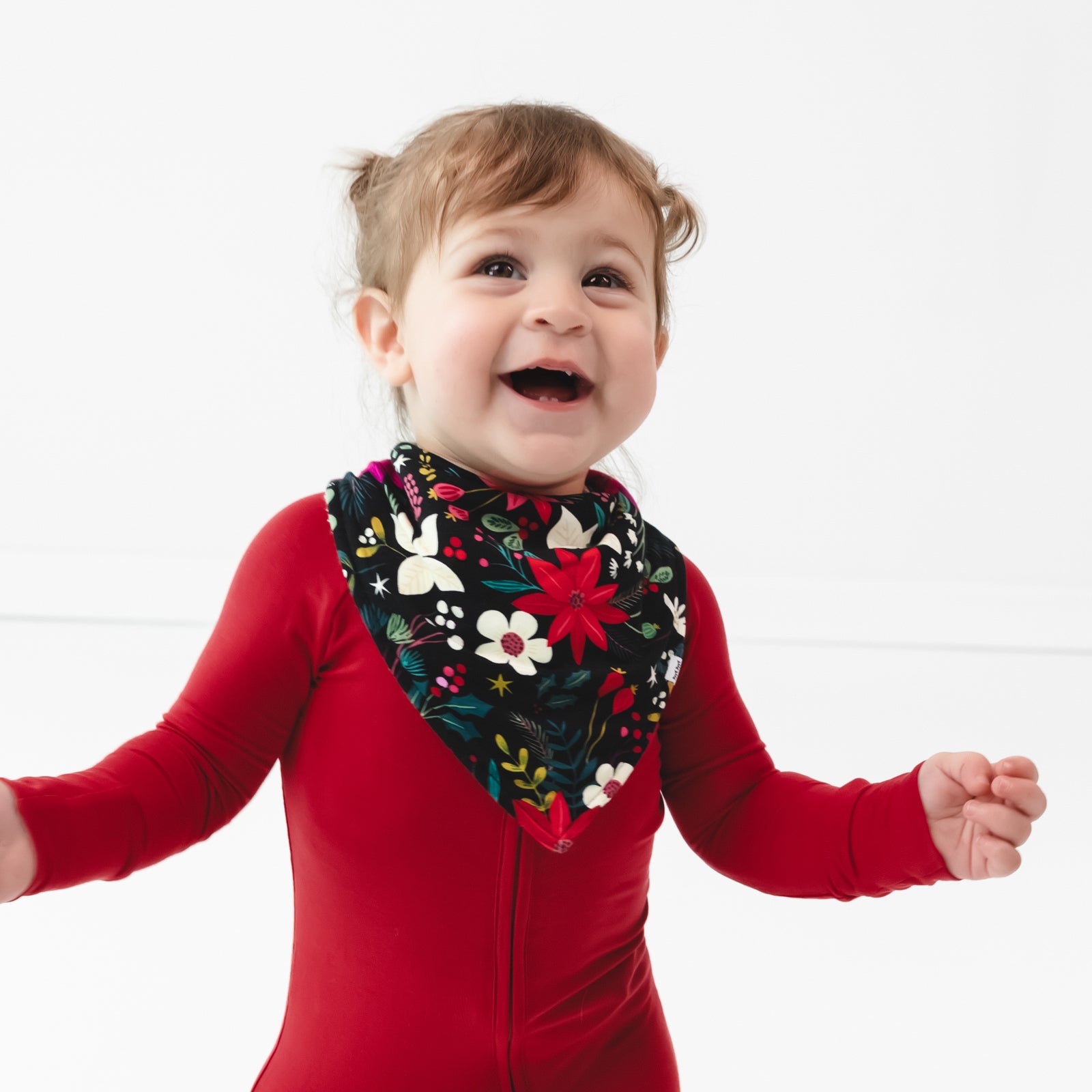 Child smiling while wearing the Berry Merry Bandana Bib and coordinating Zippy