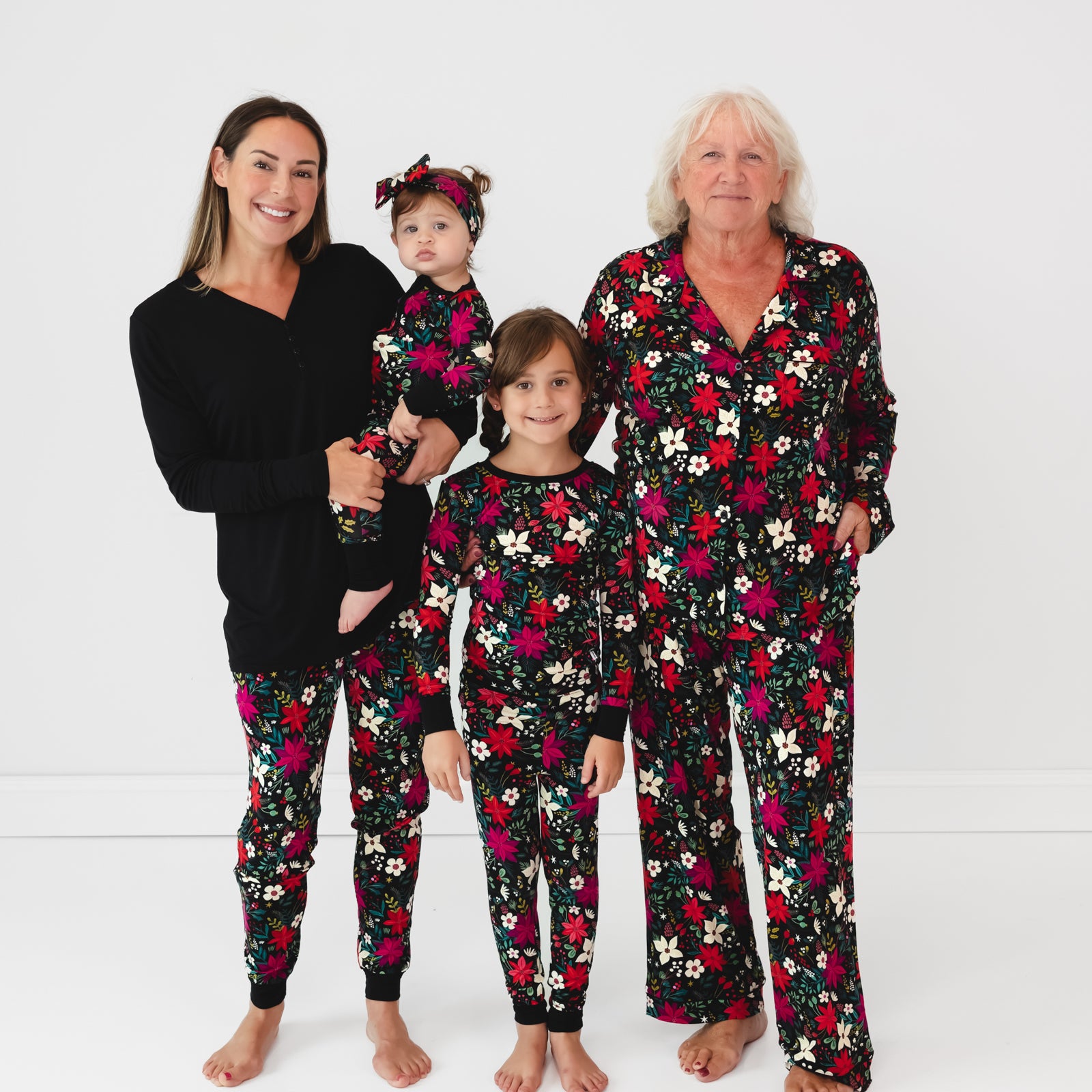 Family wearing the Berry Merry print. Baby is in the Berry Merry Zippy