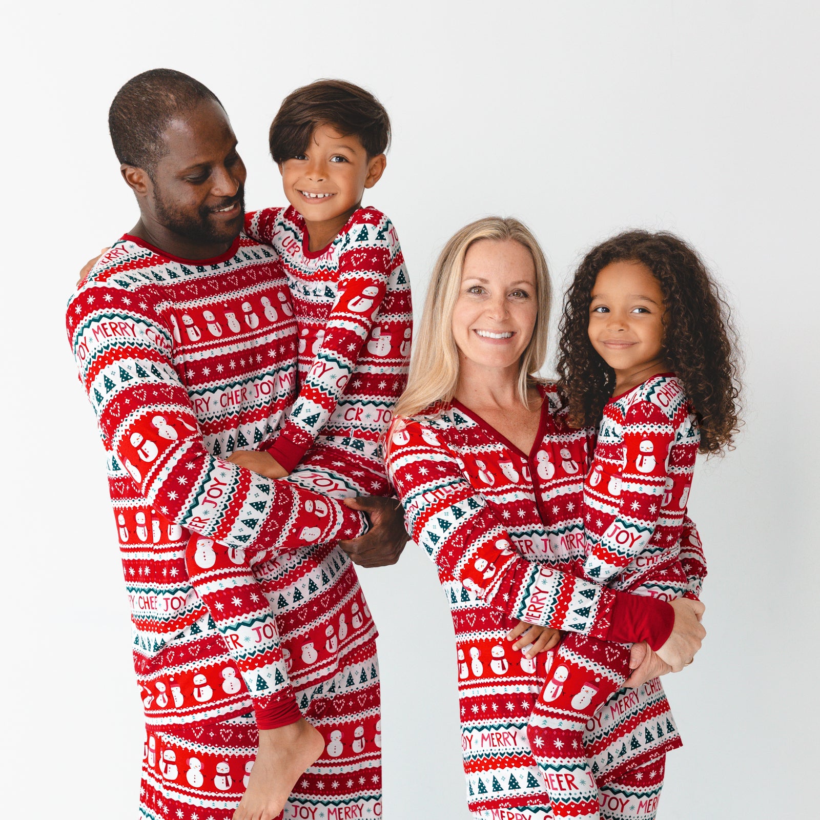 Family of four wearing matching Festive Fair Isle pajamas