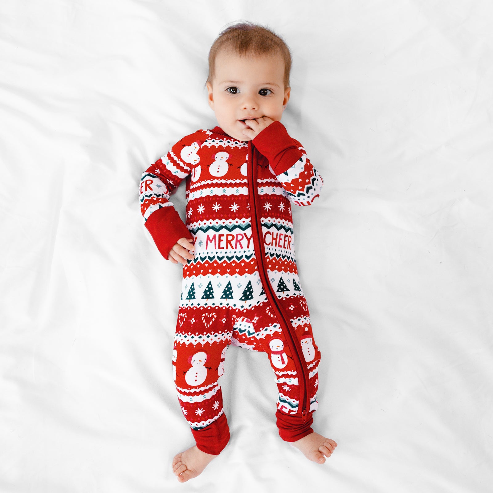 Child laying on a blanket wearing a Festive Fair Isle Zippy