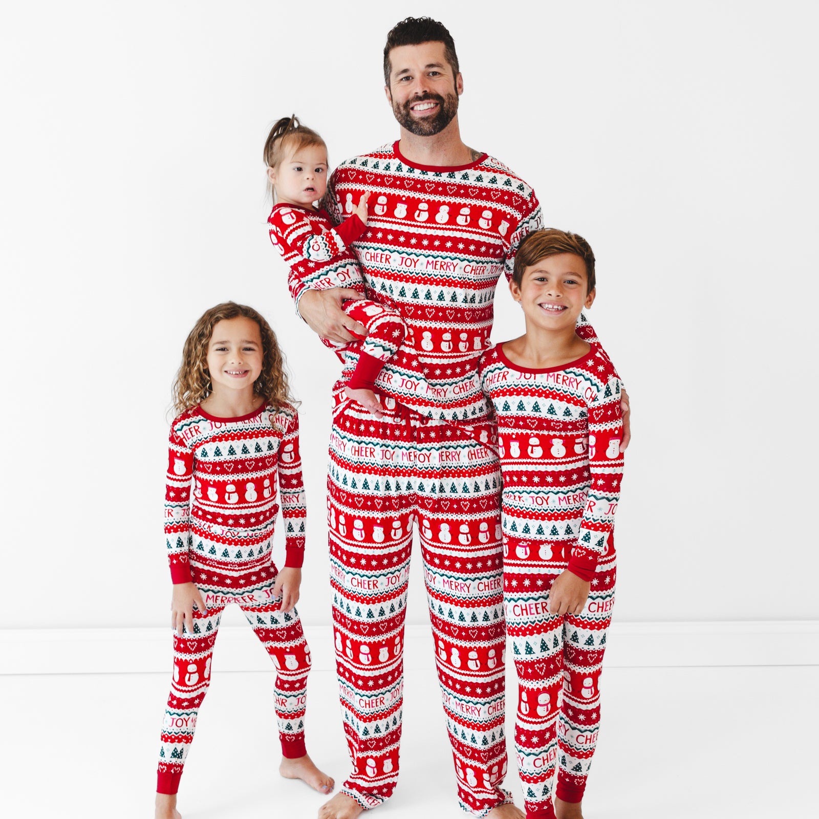 Family of four wearing matching Festive Fair Isle pajamas