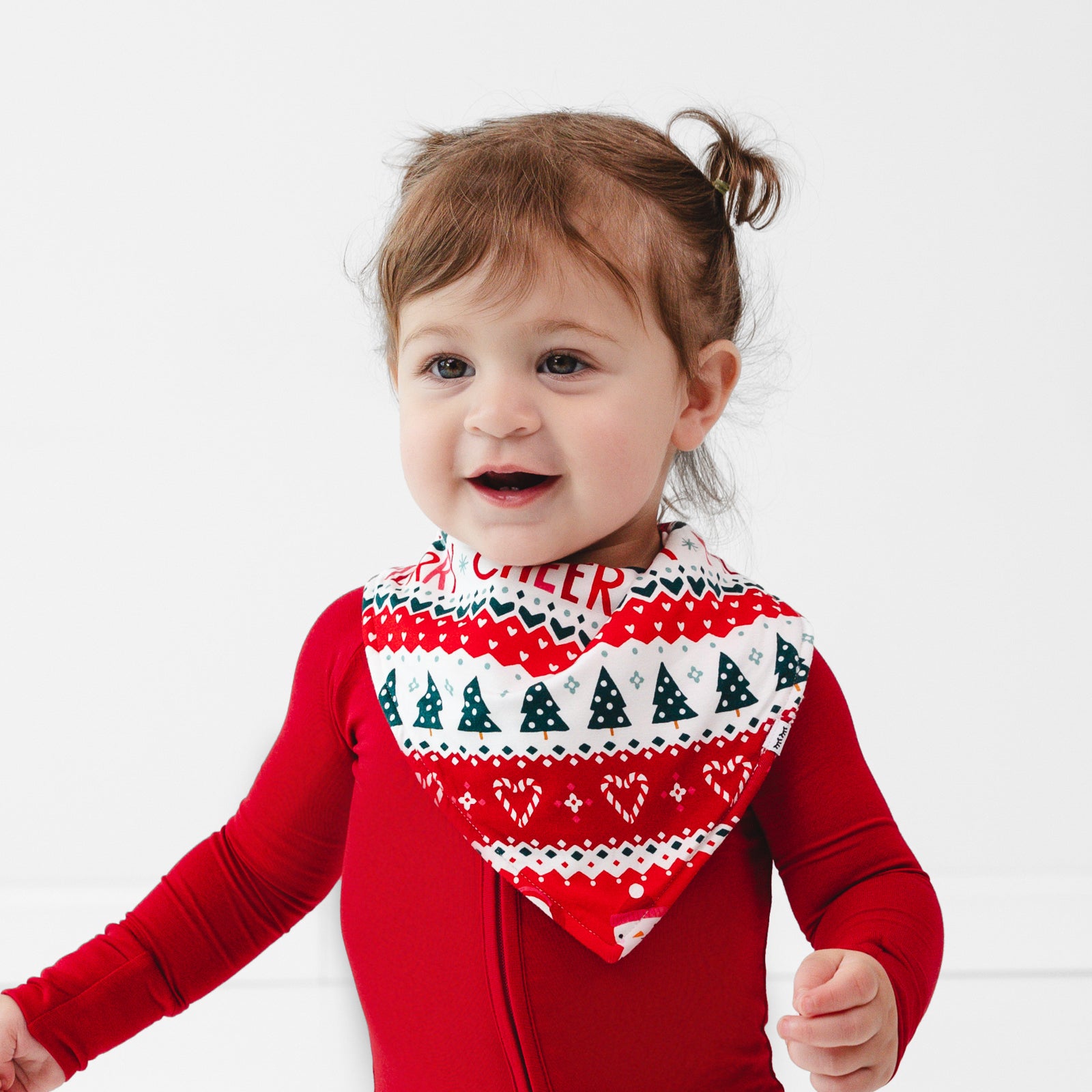 Close up image of a child wearing a Festive Fair Isle Bandana Bib and Holiday Red Zippy