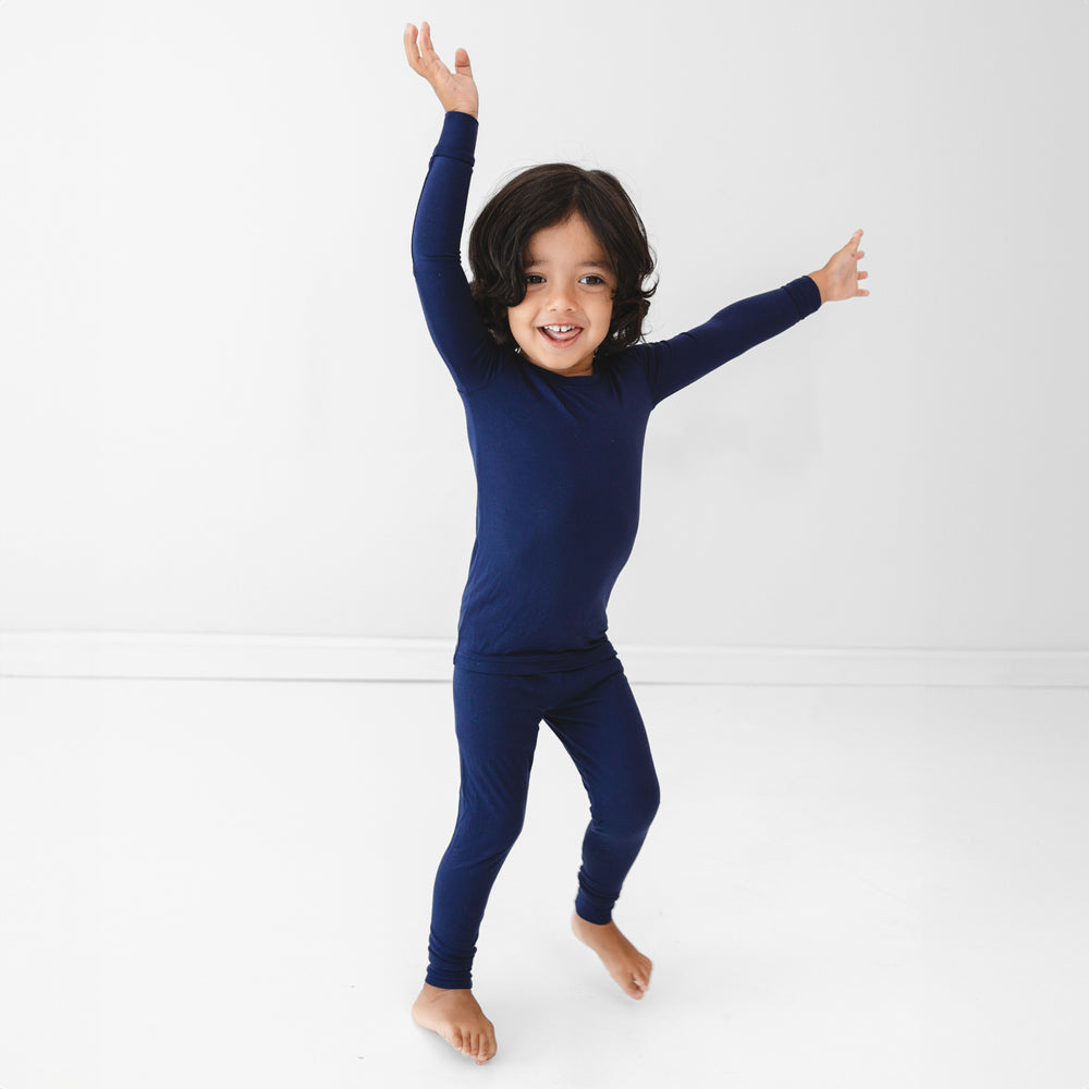 Child posing while wearing the Classic Navy Two-Piece Pajama Set