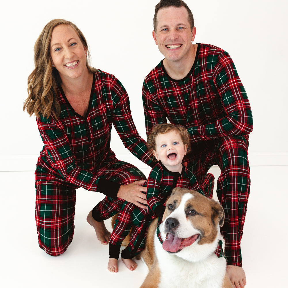 Family of three and a dog wearing matching Fireside Plaid pajamas