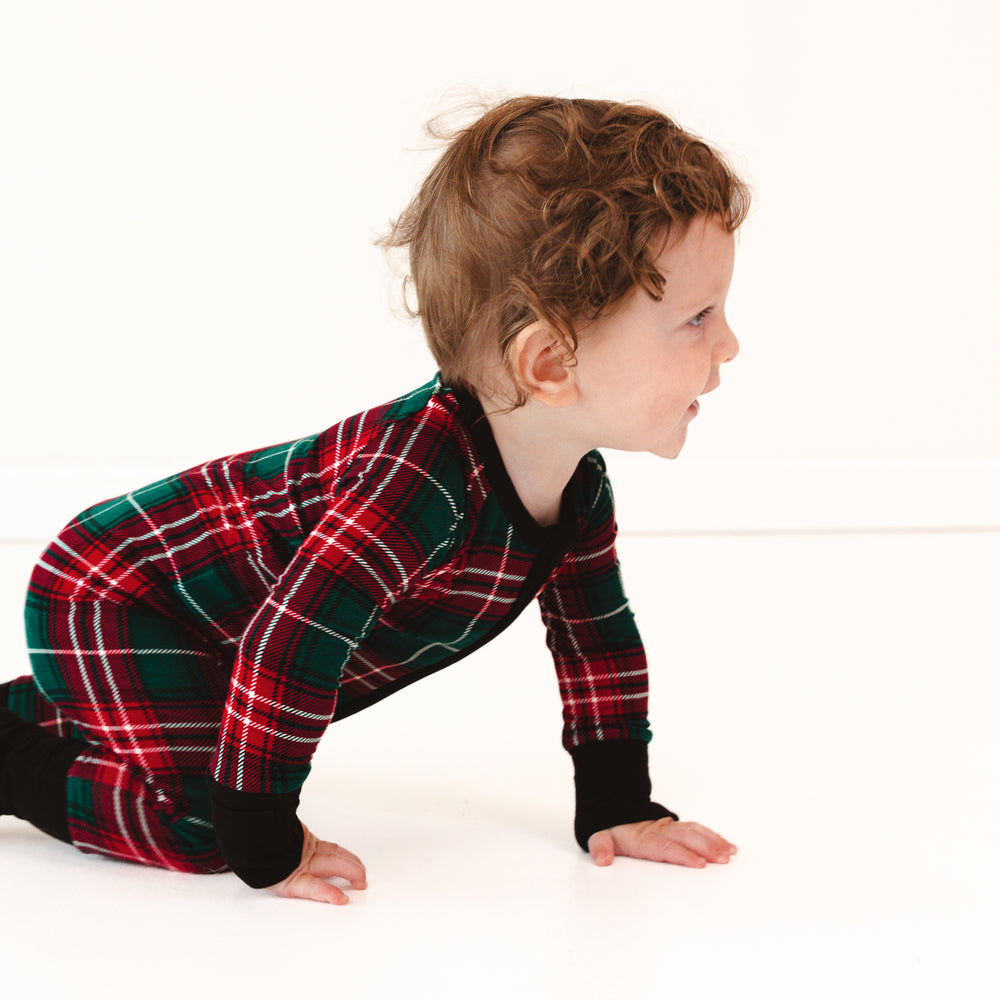 Side view image of a child crawling on the ground wearing a Fireside Plaid Zippy