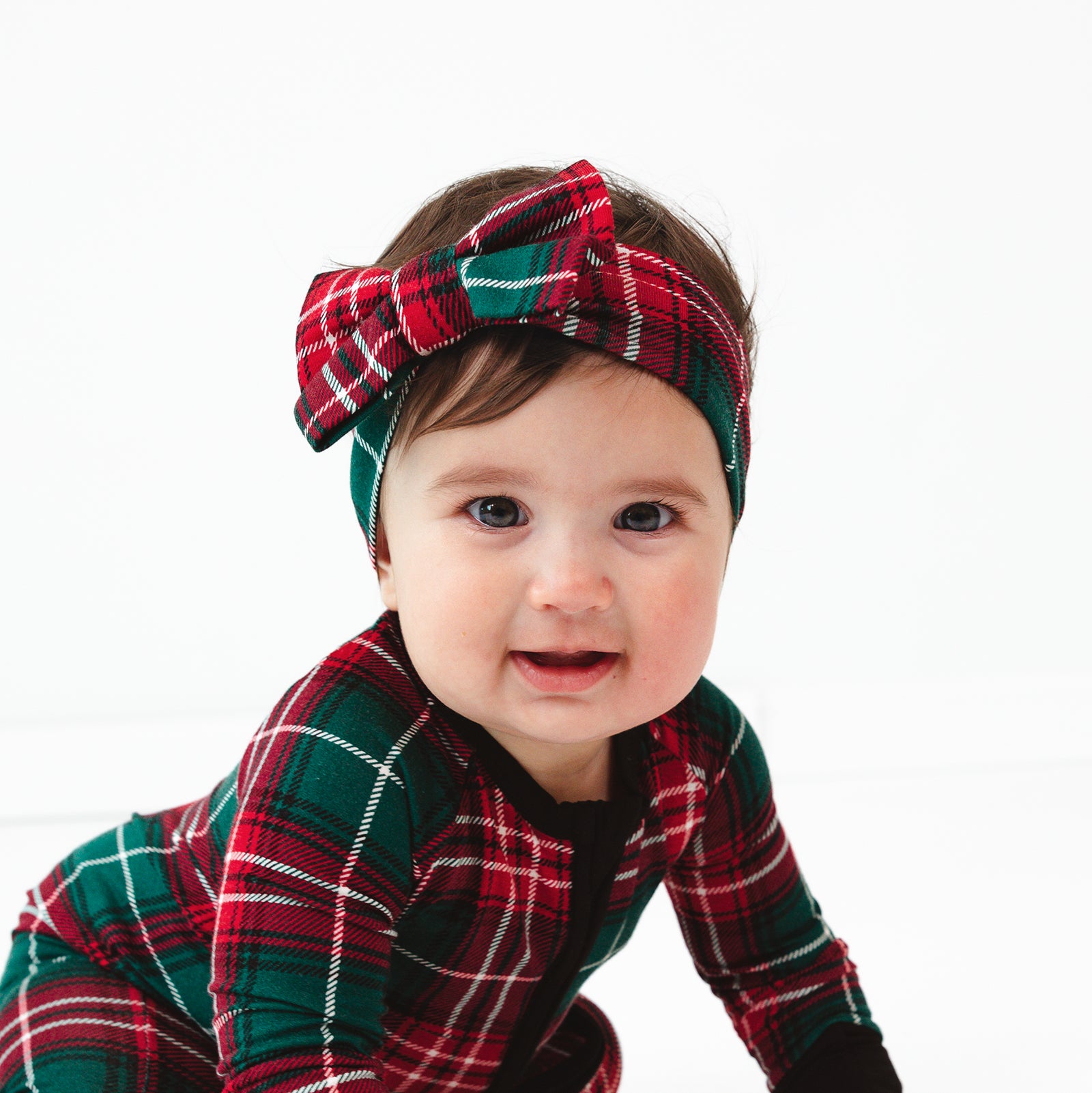 Child wearing a Fireside Plaid Luxe Bow Headband and Zippy