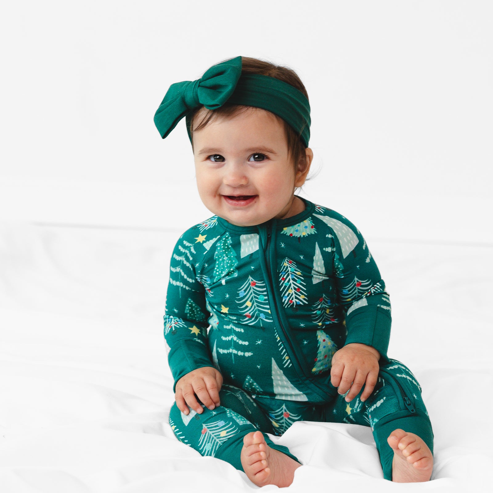 Image of baby sitting while wearing the Green Twinkling Trees Zippy and Emerald Luxe Bow Headband