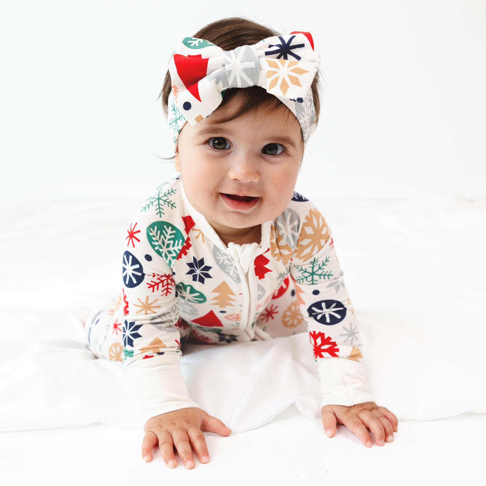 Close up image of baby crawling while wearing the Modern & Merry Luxe Bow Headband and Modern & Merry Zippy