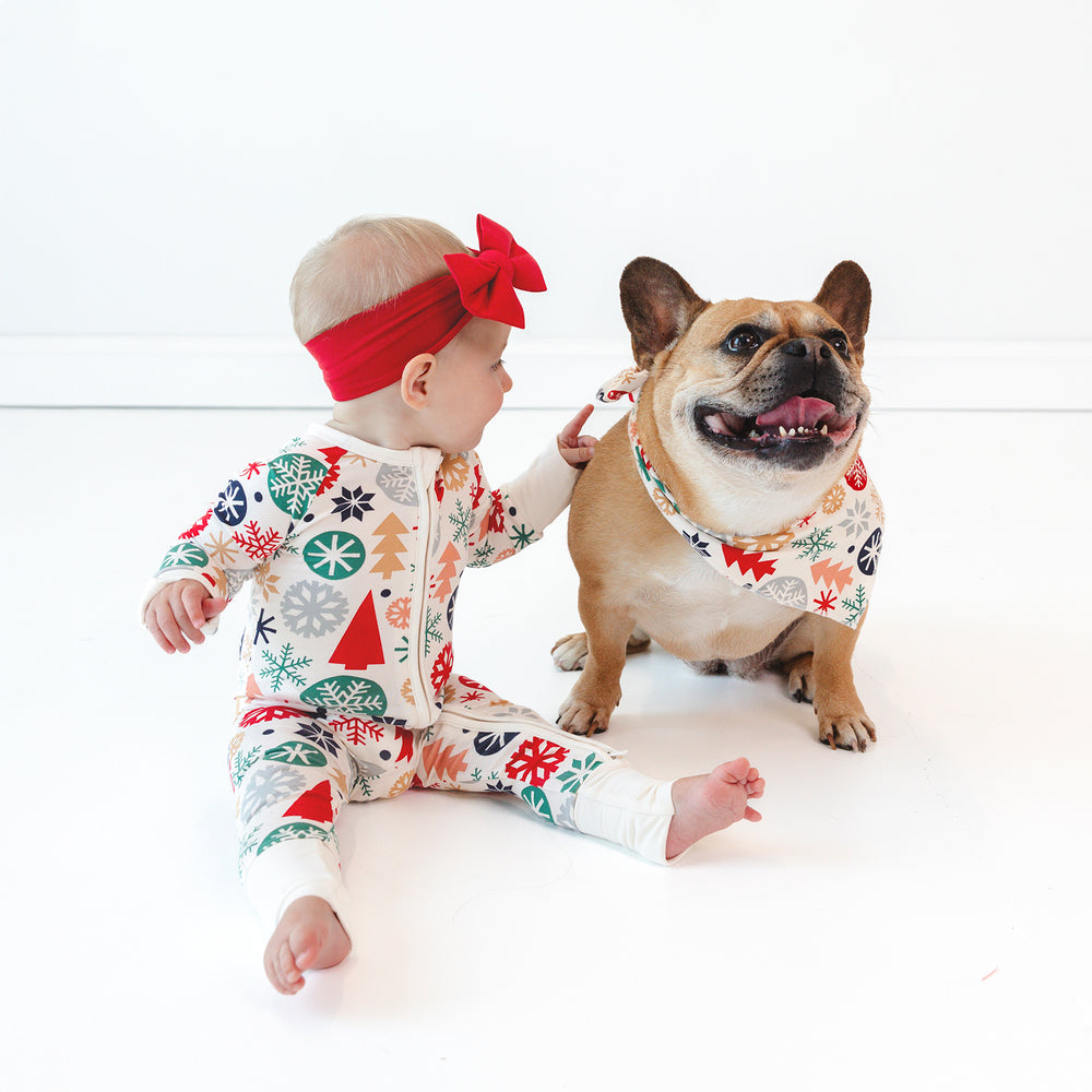 Baby sitting while wearing the Modern & Merry Zippy and Holiday Red Luxe Bow Headband. on the right the dog is in the Modern & Merry Pet Bandana