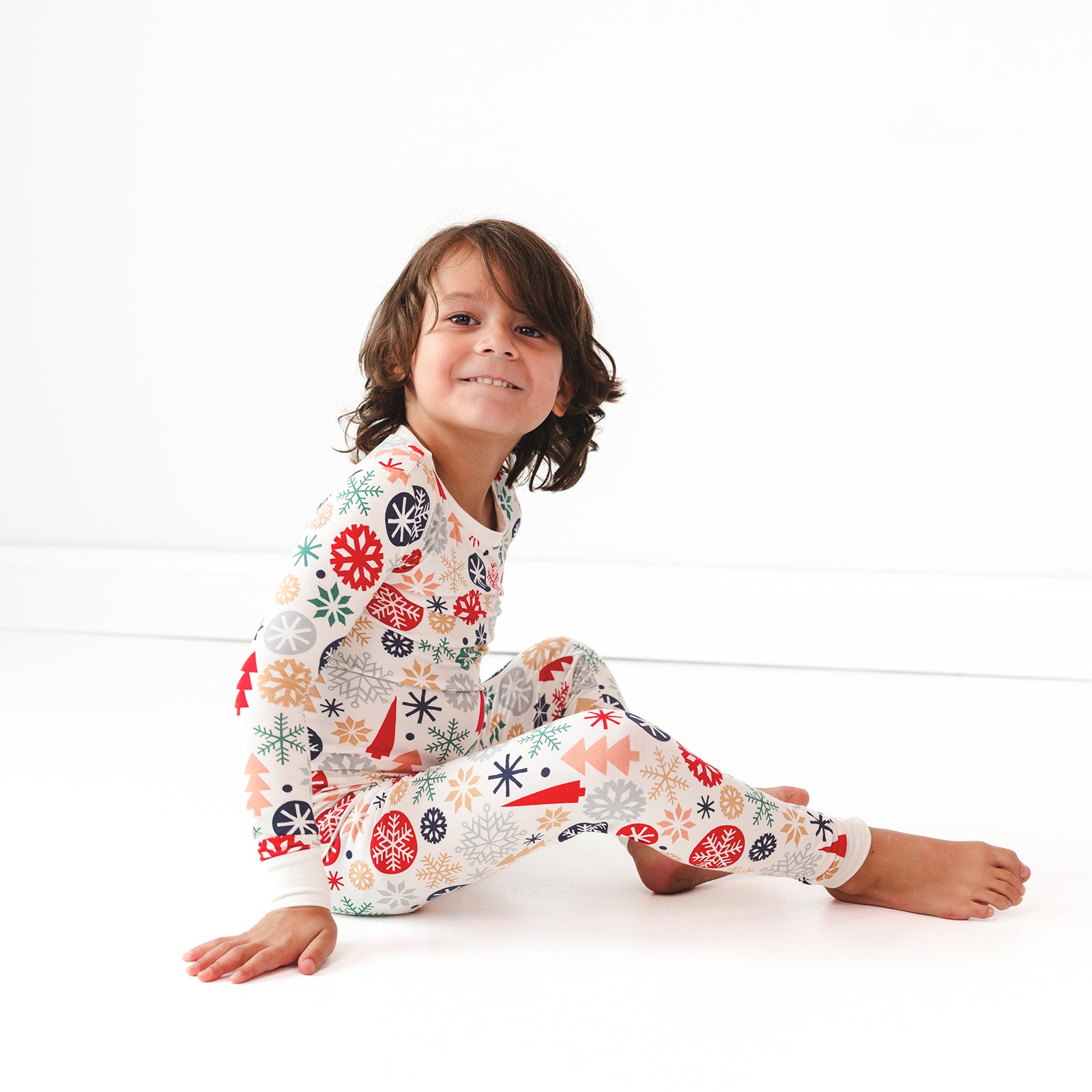 Child sitting while wearing the Modern & Merry Two-Piece Pajama Set