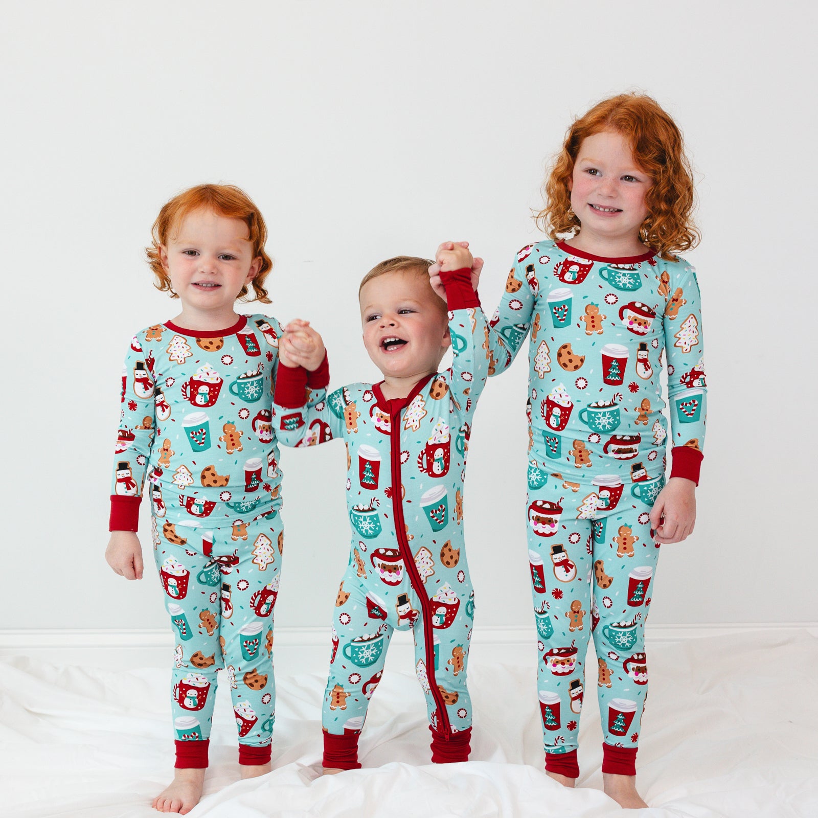 Image of three children holding hands wearing matching Peppermint Mocha pajamas