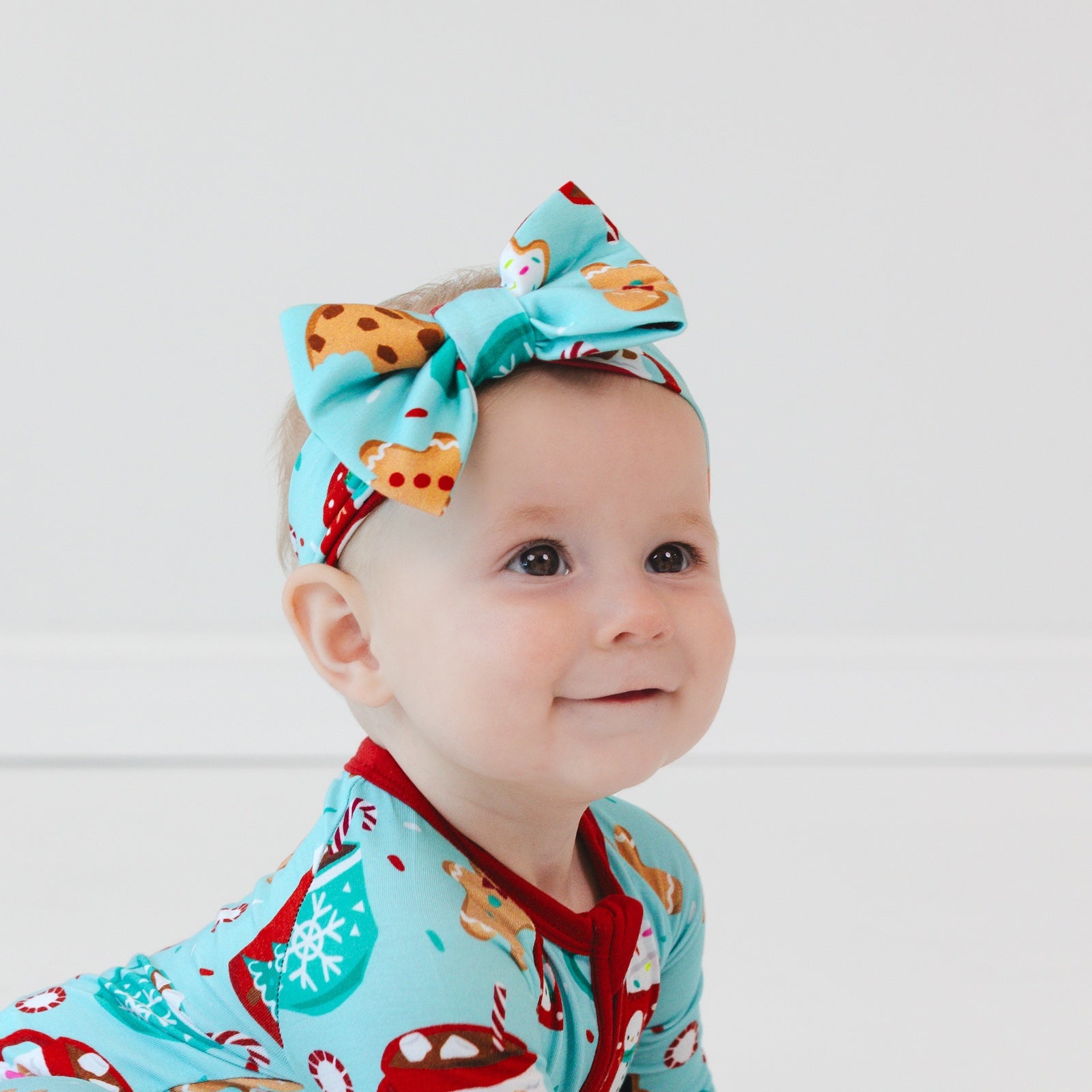 Close up image of a child wearing a Peppermint Mocha Luxe Bow Headband and matching Zippy.