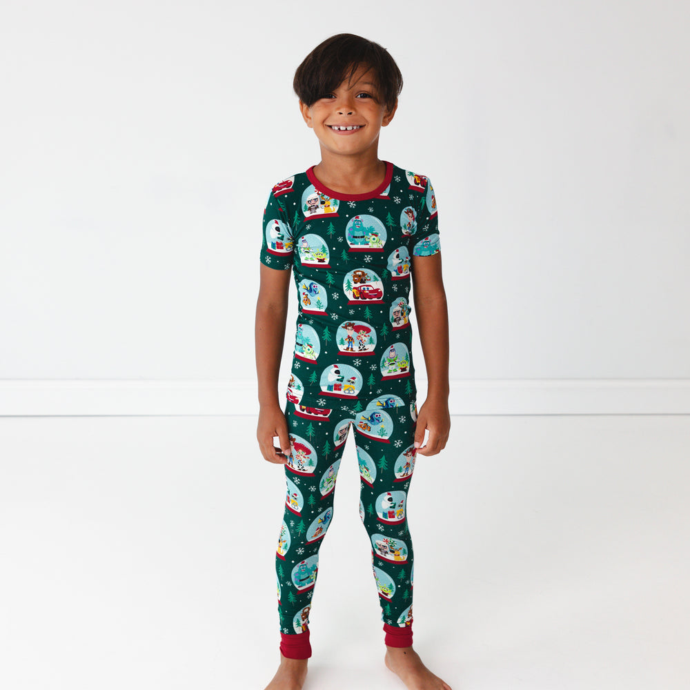 Smiling boy wearing the Disney A Very Pixar Christmas Two-Piece Short Sleeve Pajama Set