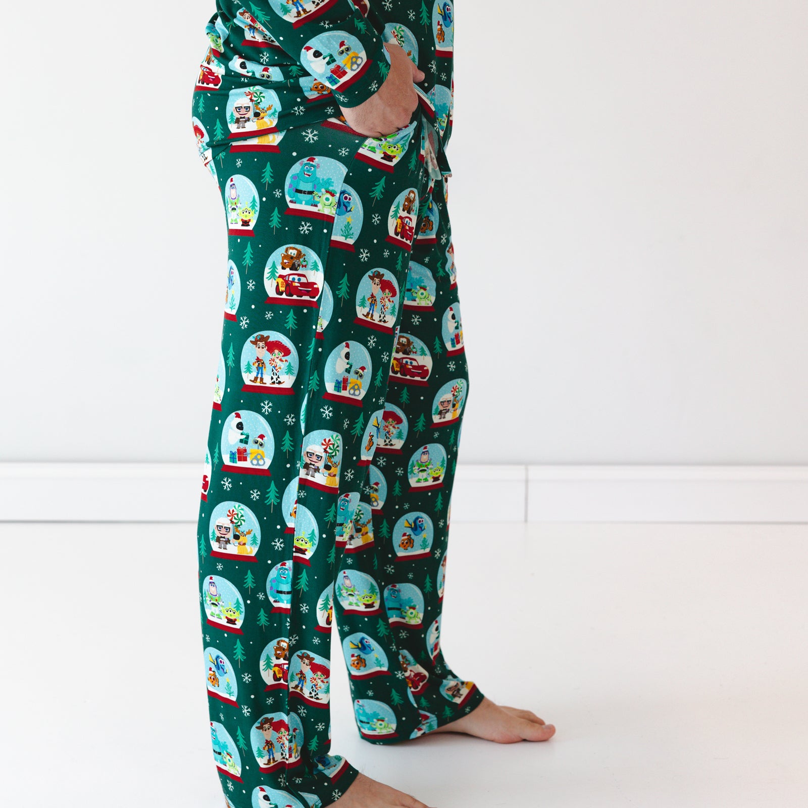 Close up side view image of male model wearing the Disney A Very Pixar Christmas Men's Pajama Pants while displaying the pockets