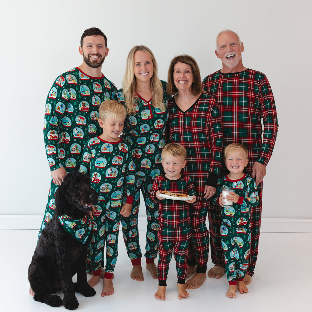 Family dressed in Little Sleepies Christmas prints. Dog on the left is in the Disney A Very Pixar Christmas Pet Bandana