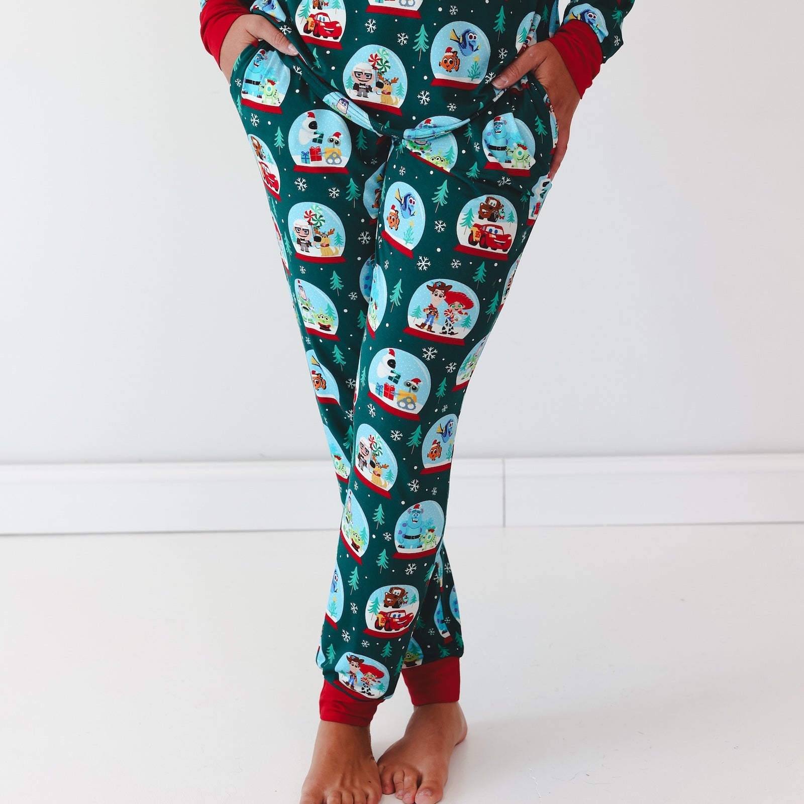 Close up image of female model wearing the Disney A Very Pixar Christmas Women's Pajama Pants with hands in pocket