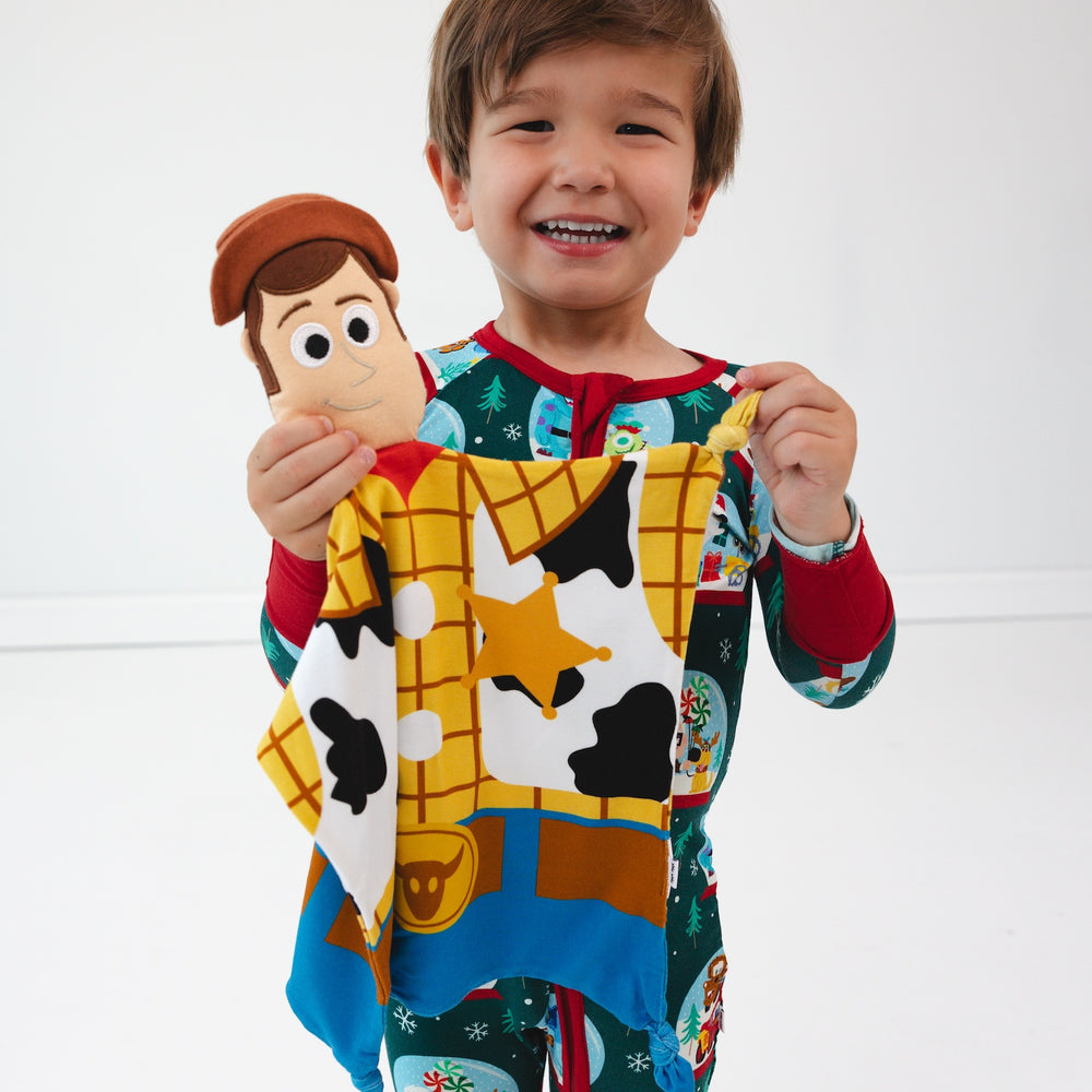 Smiling boy wearing the Disney A Very Pixar Christmas Zippy while holding up the Disney Toy Story Woody Lovey