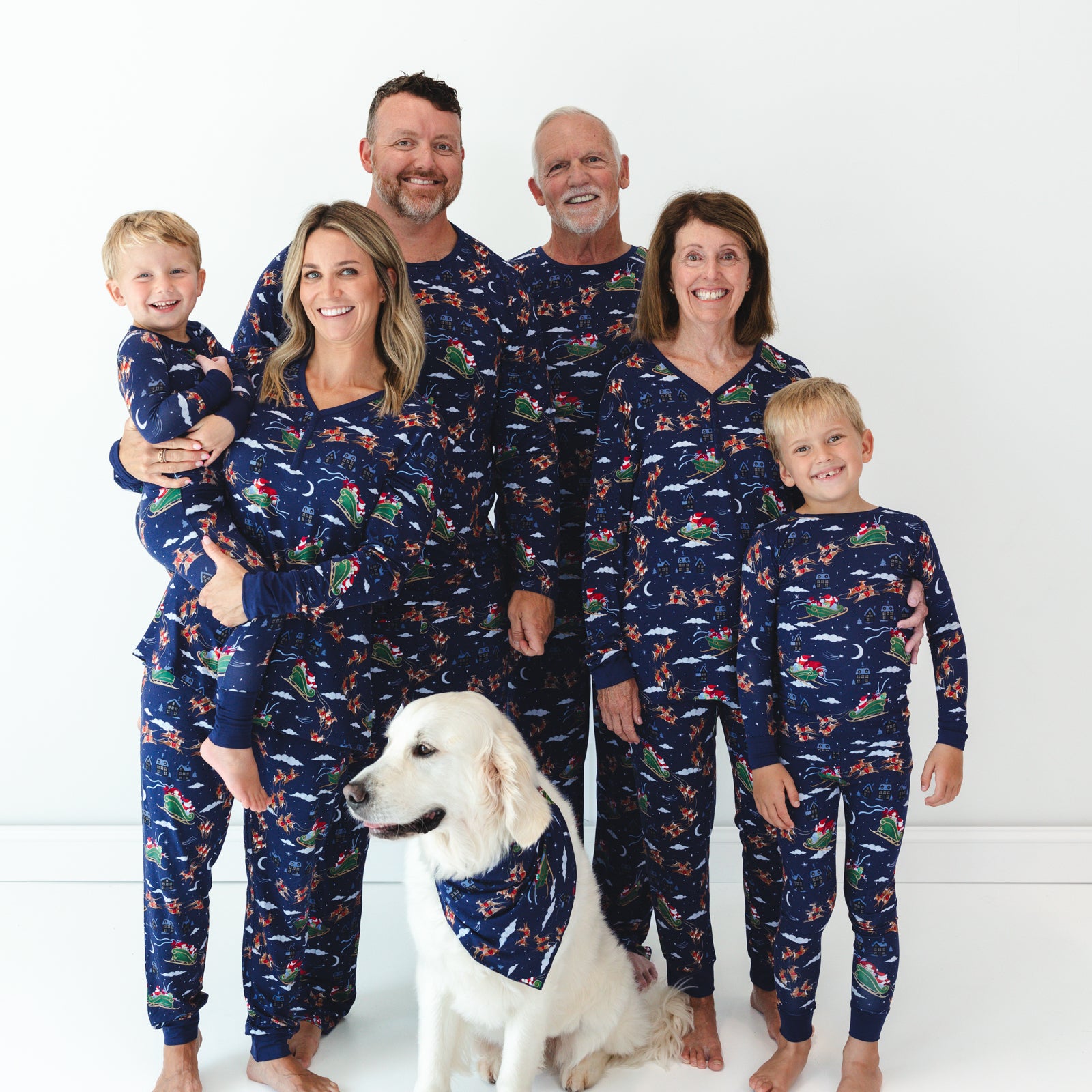 Family of six and a dog wearing matching Santa's Sleigh pajamas