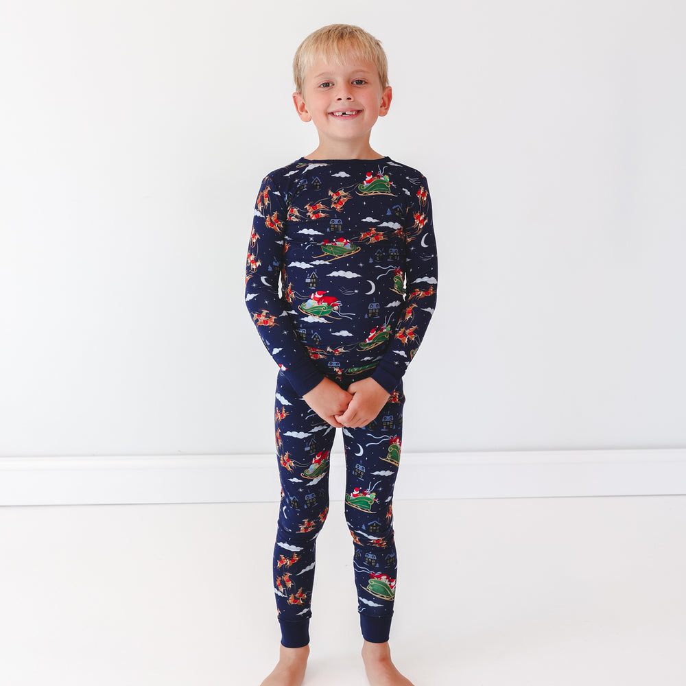 Image of a child wearing a Santa's Sleigh Two-Piece Pajama Set