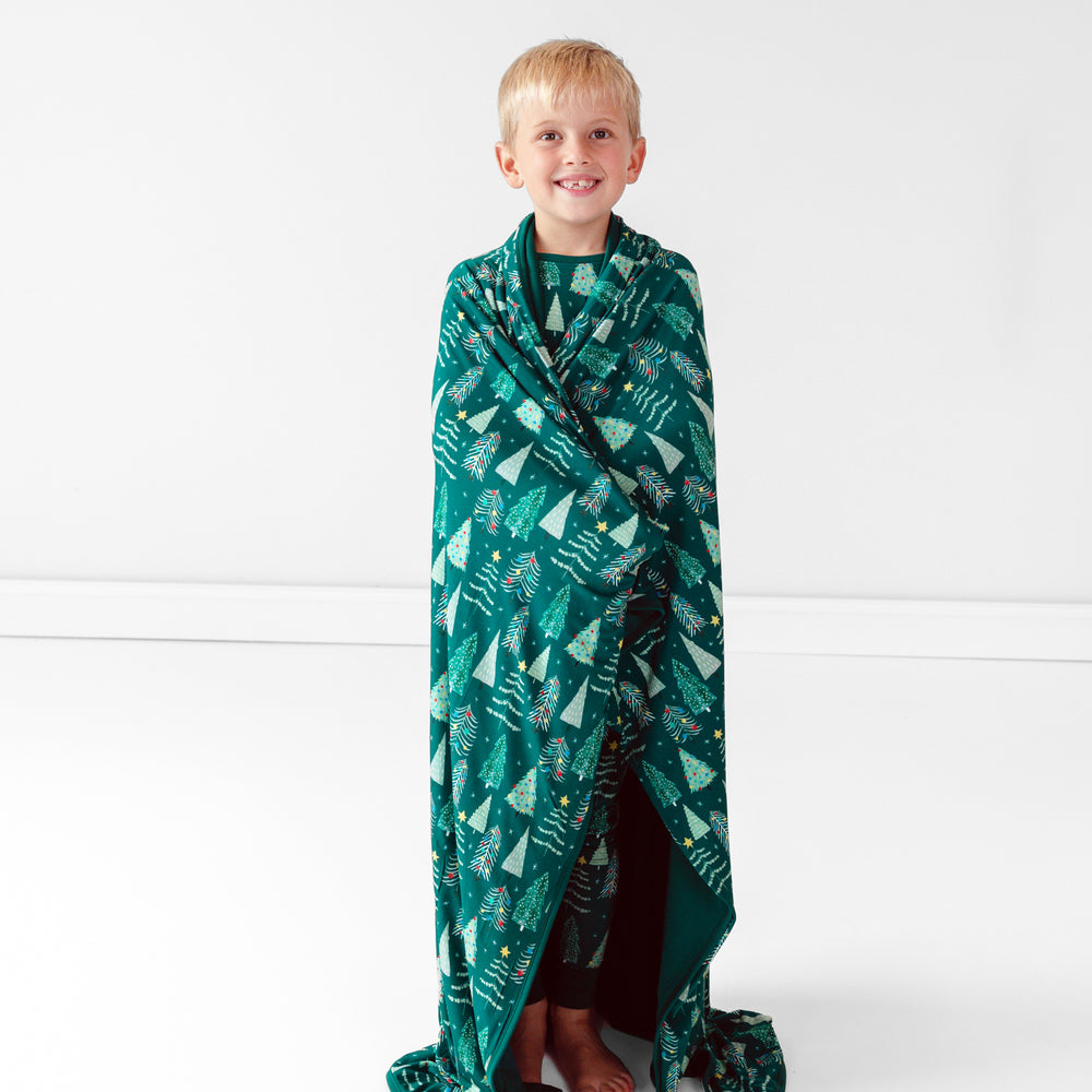 Smiling child wrapped in the Green Twinkling Trees Large Cloud Blanket®