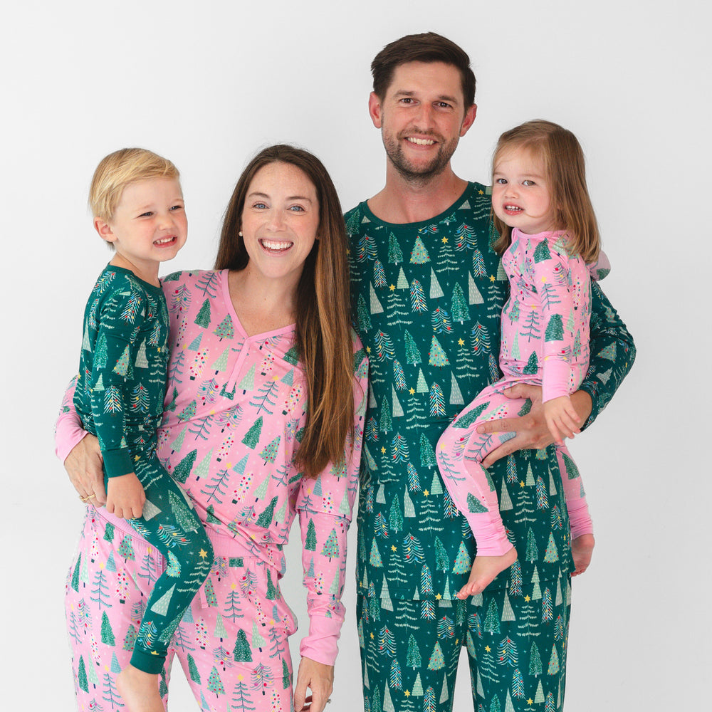 Family of four wearing matching Pink and Green Twinkling Trees pajamas