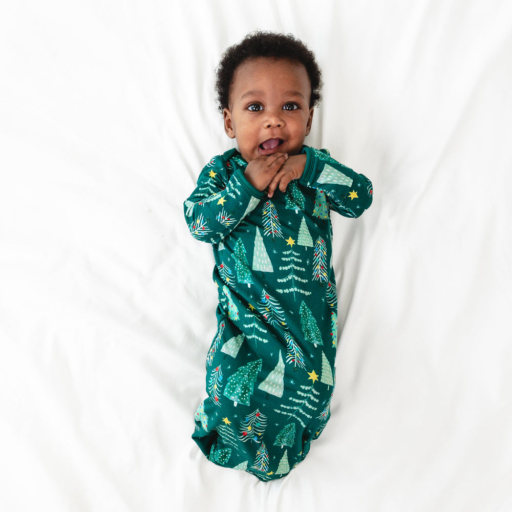 Top view image of baby laying down while in the Green Twinkling Trees Infant Gown