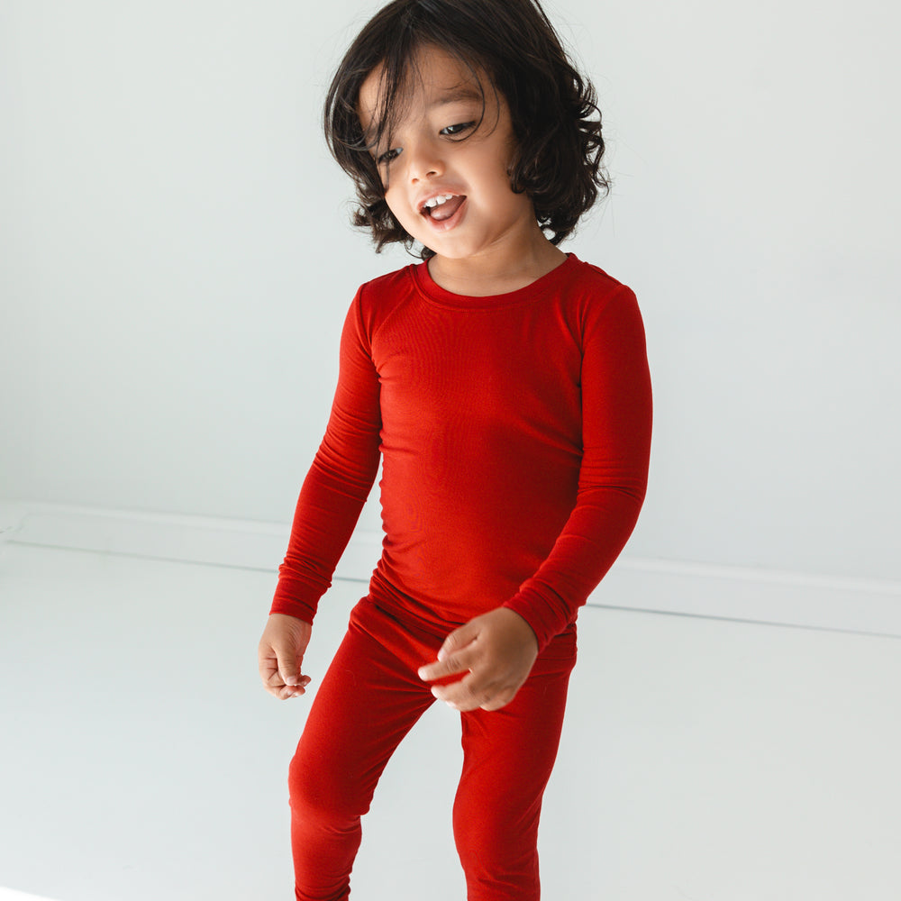 Child posing while wearing the Holiday Red Two-Piece Pajama Set