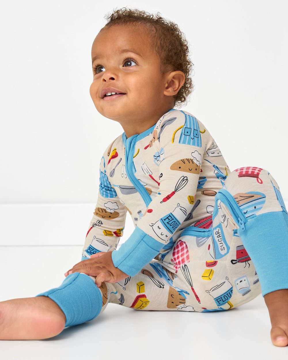 Sitting baby wearing the Little Chef Zippy