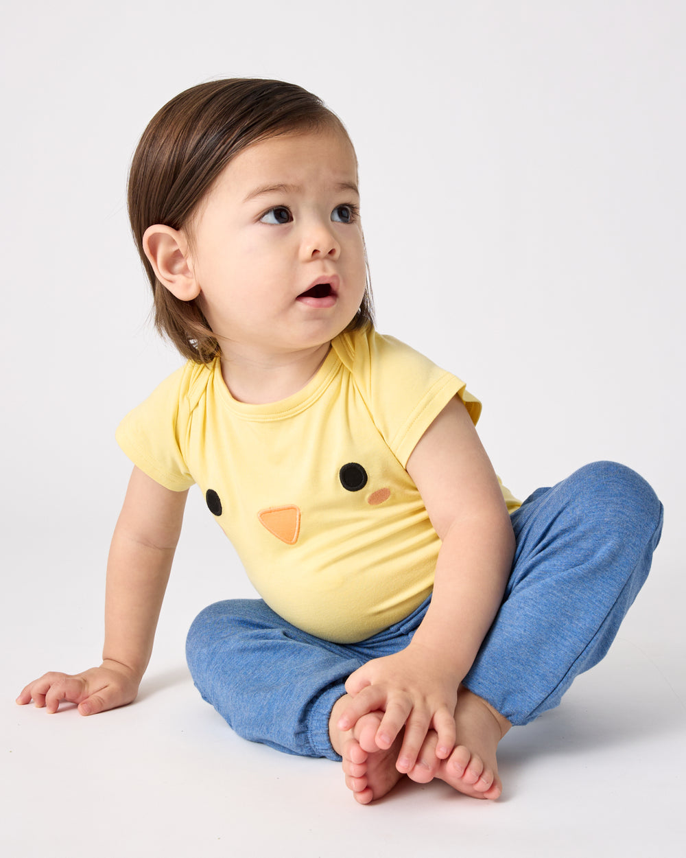 Baby wearing the Little Chickie Bodysuit with blue joggers