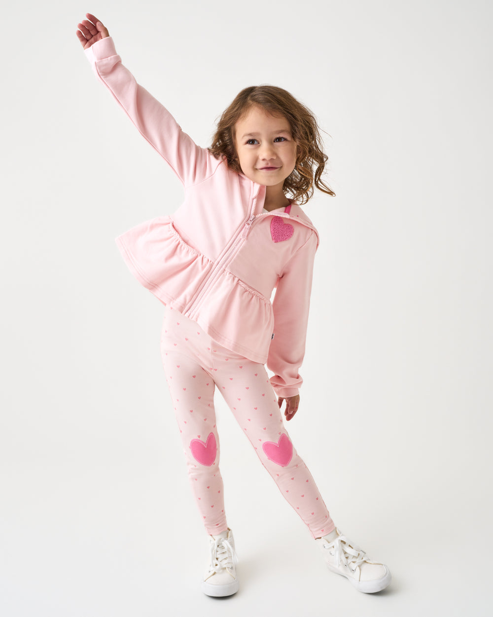 Posing child wearing the Little Love Heart Patch Legging and Zip Hoodie