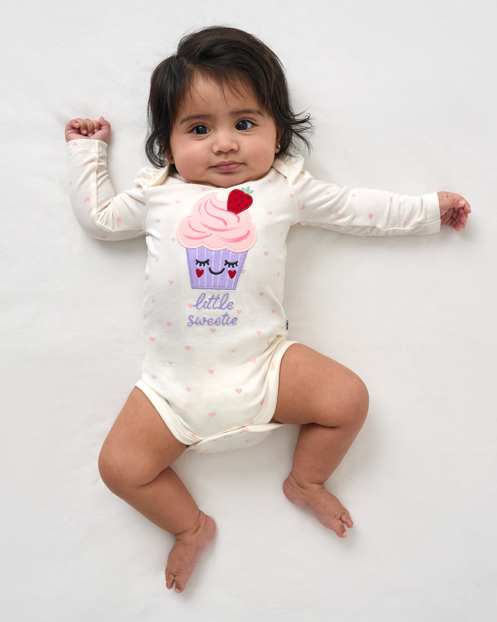 Aerial view of baby wearing the Little Sweetie Puff Sleeve Bodysuit