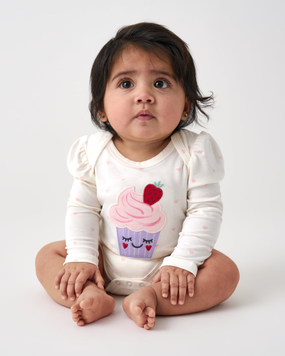 Sitting baby wearing the Little Sweetie Puff Sleeve Bodysuit