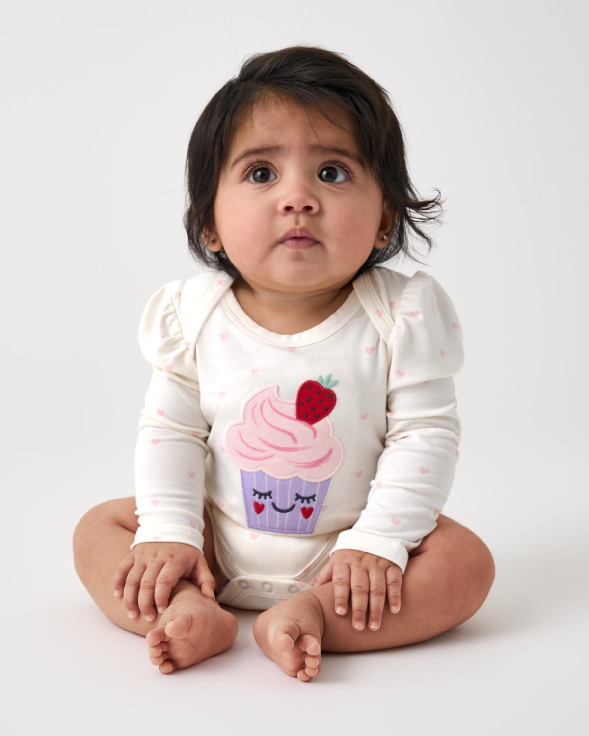 Sitting baby wearing the Little Sweetie Puff Sleeve Bodysuit
