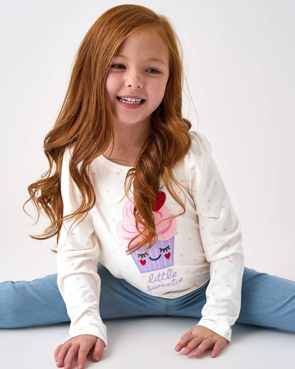 Sitting girl wearing the Little Sweetie Puff Sleeve Tee