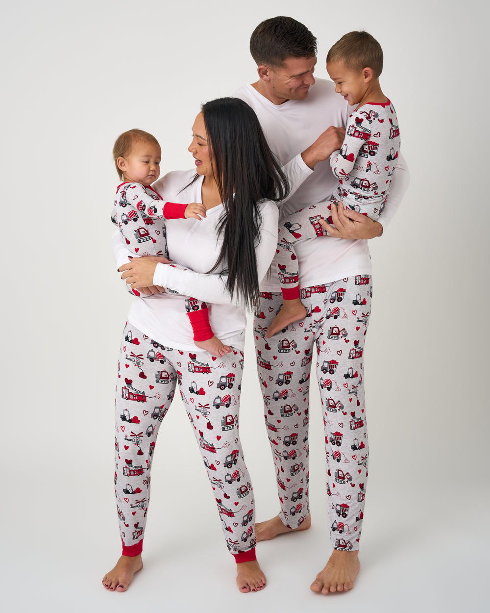Family of four wearing matching Loads of Love Valentines Pajamas